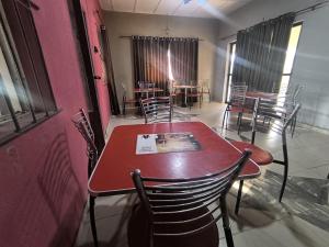 a dining room with a red table and chairs at Geobajas Hotels in Imushin