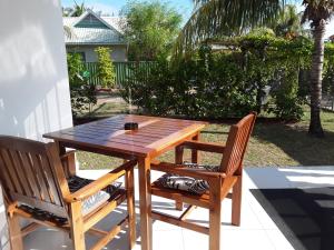 a wooden table and two chairs on a patio at Blue Sky Self Catering in Grand Anse