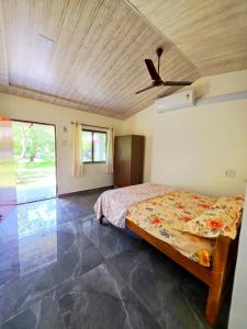 a bedroom with a bed and a ceiling fan at Chandrachhaya Agro Farms Boisar in Boisar