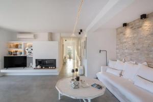 a living room with a white couch and a table at Callirhoe 180 in Poros +67 photos