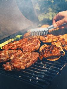 a person is cooking food on a grill at ULISI house in Verkhniy Yasenov