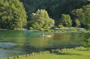 a man in a boat on a river fishing at Kuća za odmor Komić in Smrdan