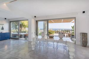 a white dining room with a table and chairs at Callirhoe 180 in Poros