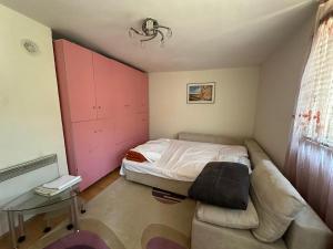 a small bedroom with a bed and a couch at Sheshi-Prizren in Prizren