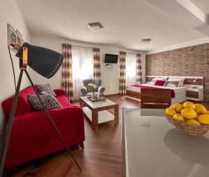 a living room with a red couch and a bed at Apartments Stella del Mare in Risan