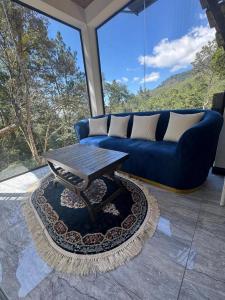 a living room with a blue couch and a table at Blue Rock Retreat in Belihuloya