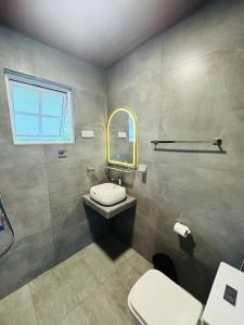a bathroom with a toilet and a sink and a mirror at Blue Rock Retreat in Belihuloya