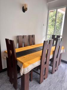 a dining room table and chairs with a yellow table cloth at Blue Rock Retreat in Belihuloya