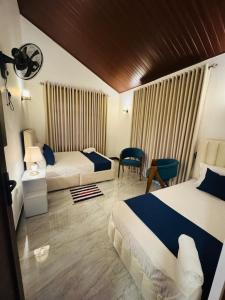 a hotel room with two beds and a table at Blue Rock Retreat in Belihuloya
