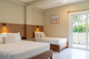 a bedroom with two beds and a window at Hotel Roca Sunzal in La Libertad