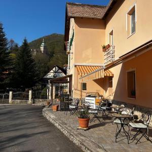 a group of tables and chairs outside of a building at Zöldfa Panzió in Miskolc +28 photos