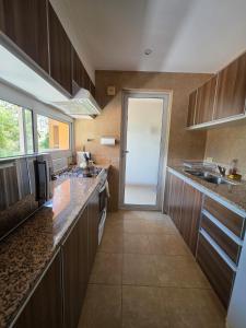 a large kitchen with wooden cabinets and counters and a door at Caseros Centro Salta in Salta