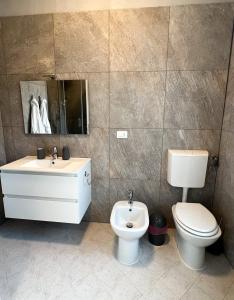 a bathroom with a toilet and a sink at Appartamento Sole in Tessera