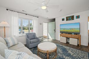 a living room with a couch and a tv at The Crabby Seahorse in Emerald Isle