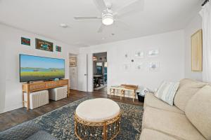 a living room with a couch and a flat screen tv at The Crabby Seahorse in Emerald Isle +35 photos