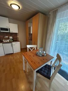 a dining room with a wooden table and a kitchen at Gästehaus Reither in Schweigen-Rechtenbach