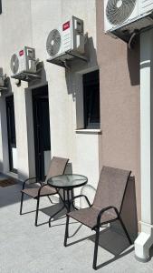 two chairs and a table in front of a building at I&I Apartment in Igalo