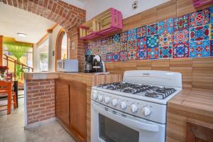 a kitchen with a stove and a tile wall at Casa divertida para grupos Plan prémium sin romper la quincena in Tequisquiapan