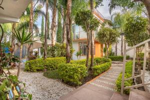 a house with palm trees and a walkway at Casa divertida para grupos Plan prémium sin romper la quincena in Tequisquiapan