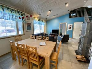 a dining room and living room with a table and chairs at VILLENKUJA 1 (3 mh ) in Tahkovuori
