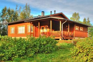 a large wooden house on a hill with trees at VILLENKUJA 1 (3 mh ) in Tahkovuori