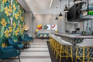 a bar in a restaurant with yellow and blue chairs at TownePlace Suites by Marriott Orlando Near Universal in Orlando