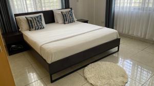 a large bed in a bedroom with a large window at Karibu comfort in Kisumu