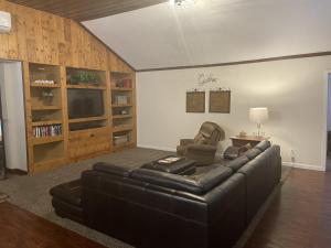 a living room with a leather couch and a television at Rustic Ridge in Granite Dells in Prescott