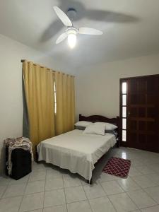 a bedroom with a bed and a ceiling fan at Brilho do Sol in Guarapari