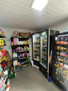 a store with two refrigerators in a room with drinks at Brilho do Sol in Guarapari