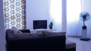 a living room with a couch and a flat screen tv at sempri djuntu T1A in Tarrafal
