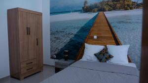 a bedroom with a bed and a wooden pier at sempri djuntu T1A in Tarrafal +4 photos