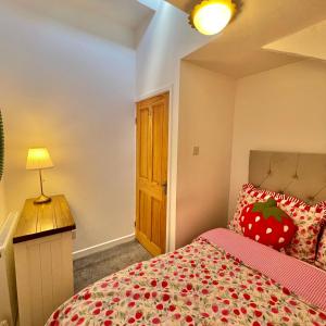 a bedroom with a bed with a red bedspread at Bear Cottage - Waterfall Country in Glyn Neath