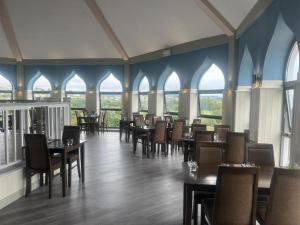 a dining room with tables and chairs and windows at Hoburne Devon Bay - 2 Bed Caravan - Activity Passes Included in Goodrington