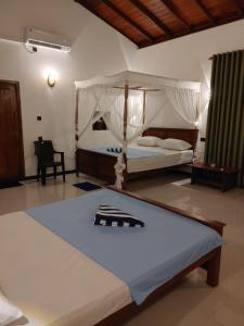 a bedroom with a bed with a canopy at Nature Velora Villa in Tangalle