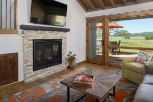 a living room with a fireplace and a television at 63 Meadow House in Sunriver