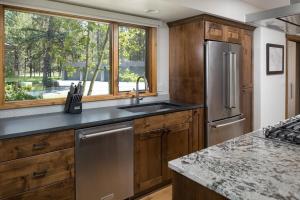 a kitchen with wooden cabinets and a stainless steel refrigerator at 63 Meadow House in Sunriver +19 photos