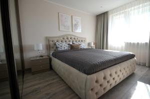 a bedroom with a large bed and a window at E.D. Luxury Apartaments in Šiauliai