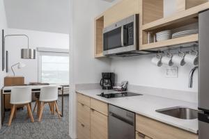 a kitchen with wooden cabinets and white counter tops at TownePlace Suites by Marriott Orlando Near Universal in Orlando