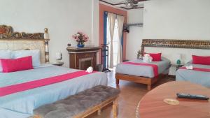 a bedroom with two beds with red and white sheets at Mesón Yollotl in Puebla