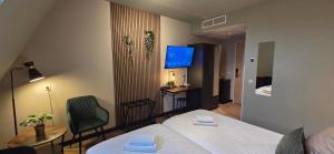 a hotel room with two beds and a television at Hotel Restaurant 't Trefpunt in Made +63 photos
