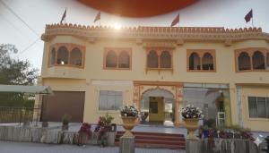 a yellow building with flowers in front of it at Hotel om banna in BhÄdura