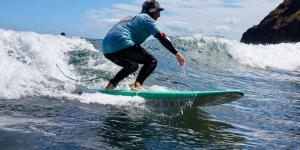 a man riding a wave on a surfboard in the water at Surf sky tamraght in Agadir +12 photos