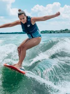 a young girl riding a wave on a surfboard in the water at Surf sky tamraght in Agadir