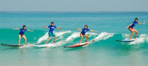 a group of women riding a wave on surfboards at Surf sky tamraght in Agadir