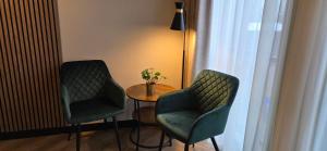 a room with two chairs and a table and a lamp at Hotel Restaurant 't Trefpunt in Made