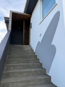 a stairway leading up to a building with a shadow at Whale House in Keflavík