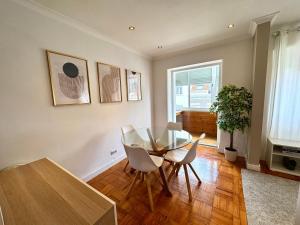 a dining room with a glass table and white chairs at Aura Campo de Ourique - Near the Tram 28 stop in Lisbon +16 photos