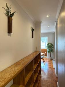 a hallway with wooden shelves and plants on the wall at Aura Campo de Ourique - Near the Tram 28 stop in Lisbon