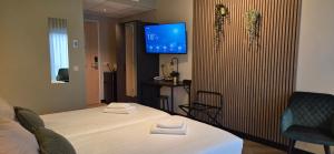 a hotel room with a bed and a tv at Hotel Restaurant 't Trefpunt in Made